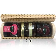 Coffre en osier beige avec confiture de fraises, cerises et miel