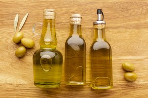 close-up-olive-bottles-yellow-olives-leaves